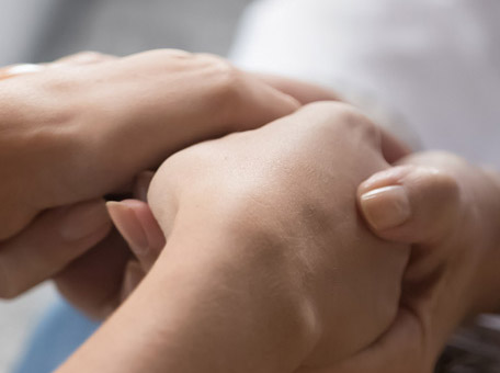 Nahaufnahme zweier Hände, die sich halten. Symbolisch für menschliche Nähe, Vertrauen und therapeutische Unterstützung